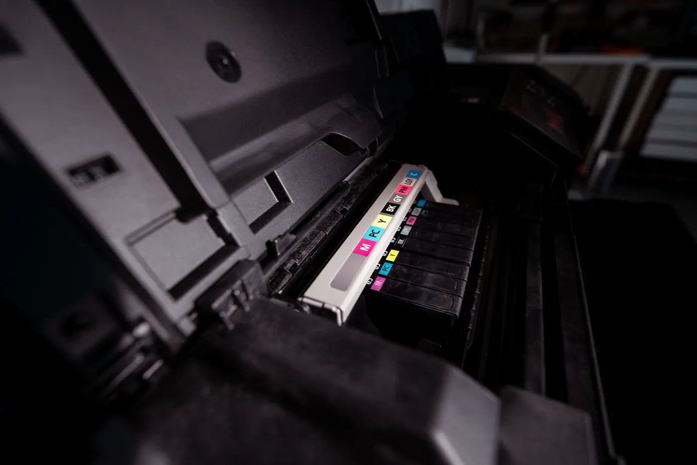 Open inkjet printer showing a row of generic color-coded ink cartridges